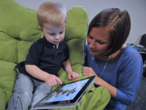 child with mother interacting with online reading games